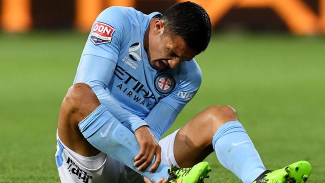 Socceroos striker Tim Cahill holds his ankle after rolling it while playing for Melbourne City on Friday night.