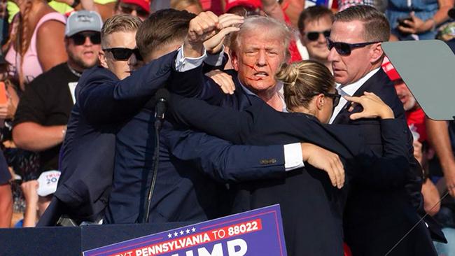 Republican candidate Donald Trump is surrounded by secret service agents as he is taken off the stage at a campaign event at Butler Farm Show Inc. in Butler, Pennsylvania, July 13, 2024. Picture: Rebecca Droke / AFP