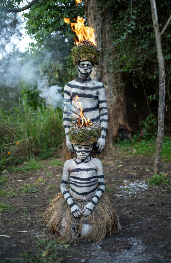In Papua New Guinea, a boy and his father from the Insect Hunter tribe showcase their tradition of carrying fire for insect gathering. Picture: Tyler Schiffman