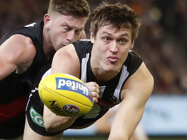 MELBOURNE, AUSTRALIA - AUGUST 23: Darcy Moore of the Magpies handpasses the ball during the 2019 AFL round 23 match between the Collingwood Magpies and the Essendon Bombers at the Melbourne Cricket Ground on August 23, 2019 in Melbourne, Australia. (Photo by Dylan Burns/AFL Photos via Getty Images)