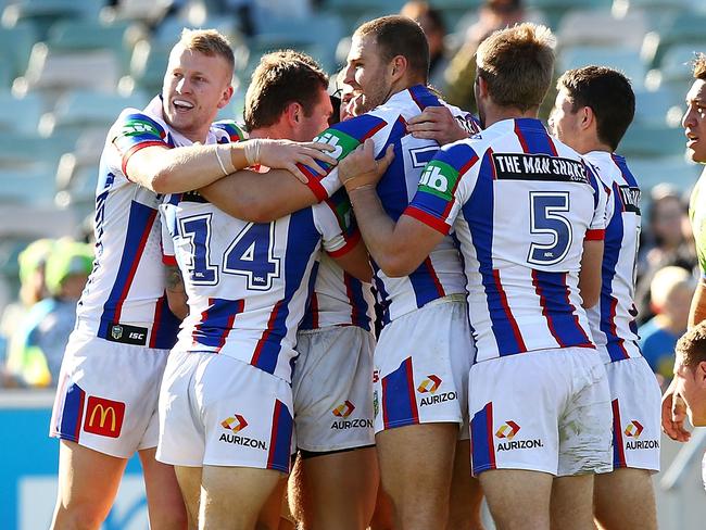 Knights players celebrate a try against the Raiders.