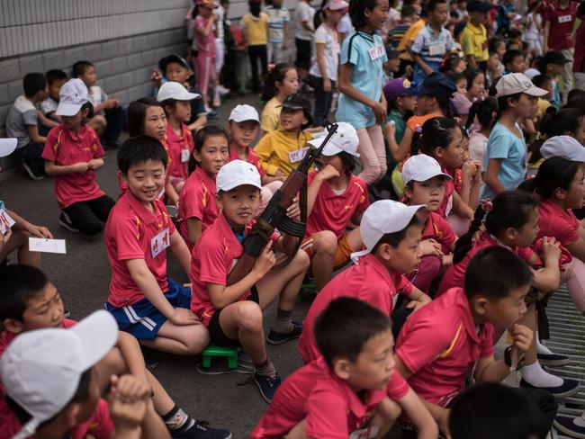 A boy holds a mock rifle as he sits with others to take part in sports games marking Children’s Union Foundation Day, in Pyongyang in June. Picture: Ed Jones/AFP