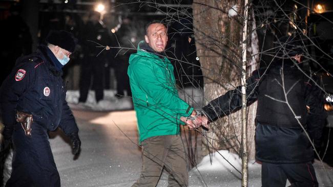 Alexei Navalny is escorted out of a police station in Khimki, outside Moscow, on Monday night. Picture: AFP