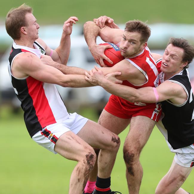 Alvie’s Patrick Seal attempts to barge through two Birregurra opponents Michael Mortimer and Mitch Russell.