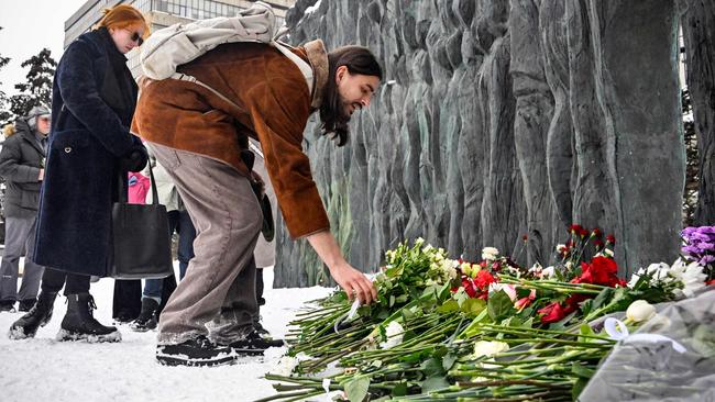 People lay flowers in Moscow at the monument to the victims of political repression after the death of Russian opposition leader Alexei Navalny. Picture: AFP