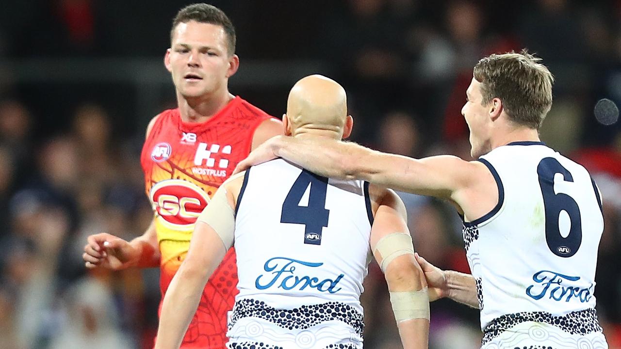 Gary Ablett of the Cats celebrates a goal in front of Steven May of the Suns.