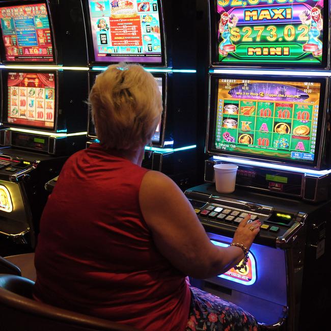 A woman tries her luck on a pokie machine.