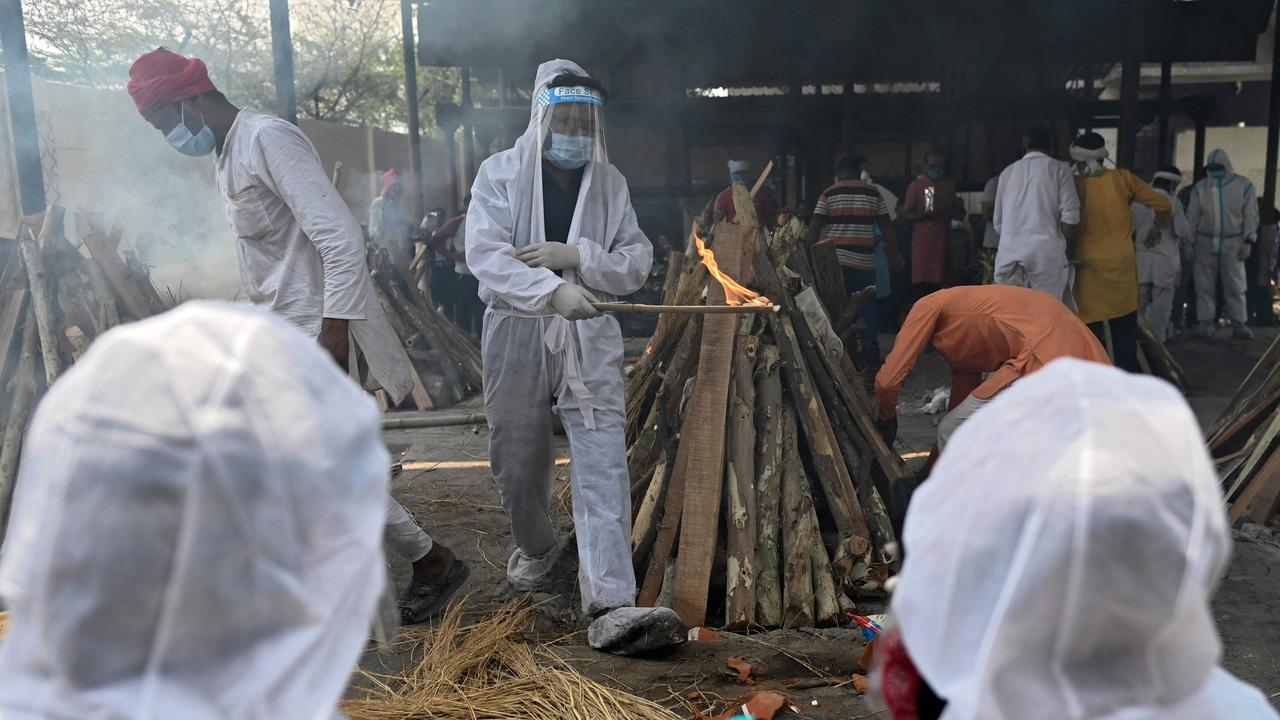 A family member wearing a protective gear performs the last rites of a victim who died of coronavirus at a crematorium in Ghazipur. Picture: Sajjad Hussain/AFP