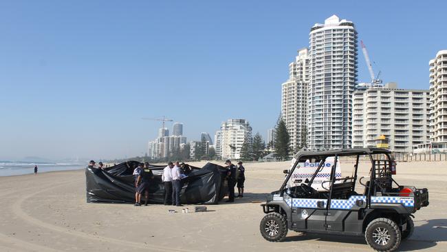 A black sheet was propped up to conceal the body of a man found on the beach at Surfers Paradise. Picture: Luke Mortimer