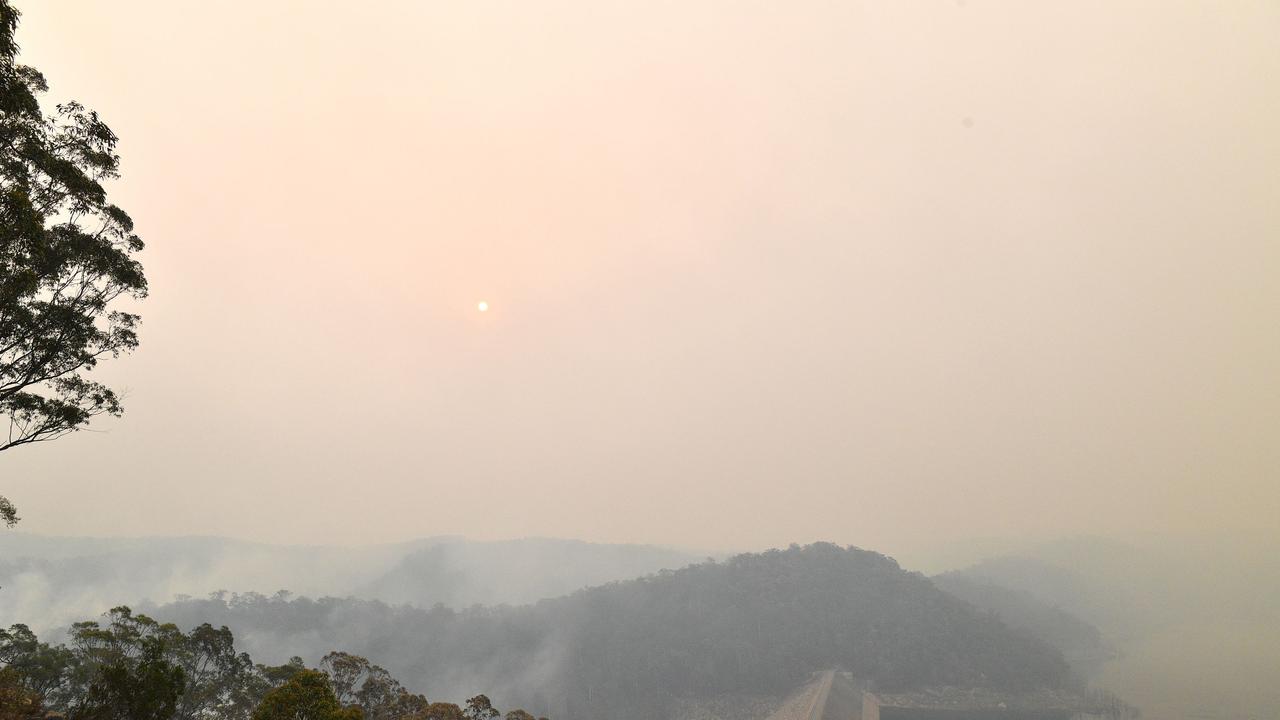 Smoke from bushfires obscuring the Mangrove Dam on the Central Coast. Picture: Saeed Khan/AFP