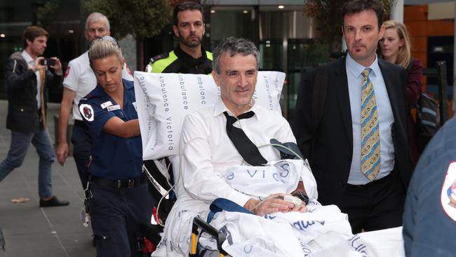 Terry McMaster leaves the Federal Court with the aid of paramedics after collapsing while being questioned during the Banking Royal Commission in Melbourne last April.