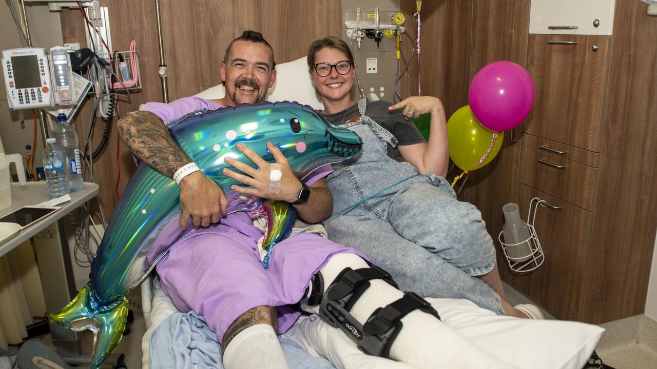 Whitsunday shark attack victim Todd Price and wife Gillian Price at Mackay Base Hospital. They are holding a dolphin balloon with shark teeth Gillian drew on. Picture: Michaela Harlow