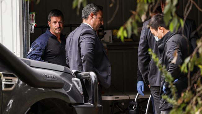 Homicide Squad detectives and AFP officers in the garage of Erin Patterson’s home. Picture: Ian Currie