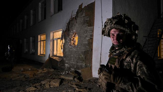 A Ukrainian soldier stands guard near debris after the reported shelling of a kindergarten. Picture: AFP