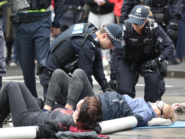 Activists from Extinction Rebellion glued themselves to the road in Melbourne on Thursday. The movement staged a "”spring rebellion” throughout the week, including marches aimed at blocking traffic. Picture: AAP Image/David Crosling