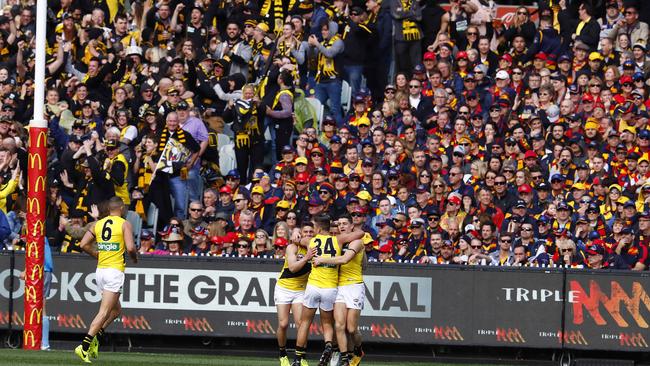 Is this really happening? Richmond fans celebrate Kane Lambert’s third quarter goal as Adelaide fans sit in quiet disbelief. Picture: Michael Klein