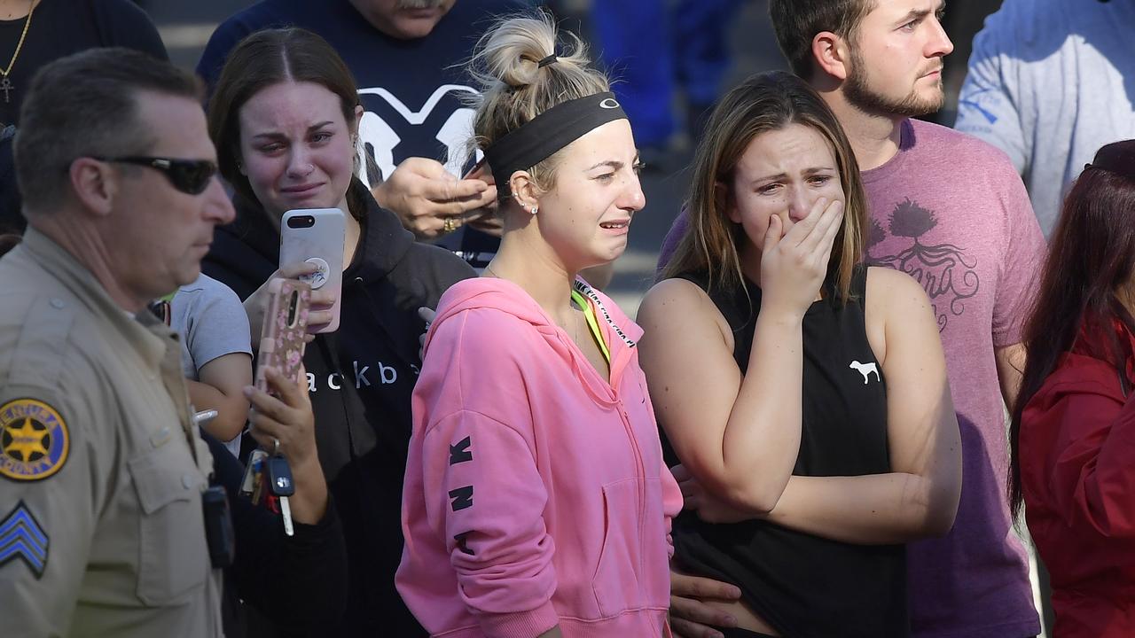 People cry as a law enforcement motorcade escorts the body of Ventura County Sheriff's Department Sgt. Ron Helus from the Los Robles Regional Medical Center. Picture: AP