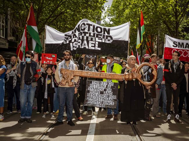 Protesters carry a symbolic key representing the right of return for Palestinian refugees, with banners calling for sanctions against Israel during the Pro-Palestine march in Melbourne. Picture: NewsWire