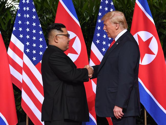 North Korea's leader Kim Jong Un (L) shakes hands with US President Donald Trump (R) at the start of their historic US-North Korea summit, at the Capella Hotel on Sentosa island in Singapore on June 12, 2018. Donald Trump and Kim Jong Un have become on June 12 the first sitting US and North Korean leaders to meet, shake hands and negotiate to end a decades-old nuclear stand-off. / AFP PHOTO / SAUL LOEB