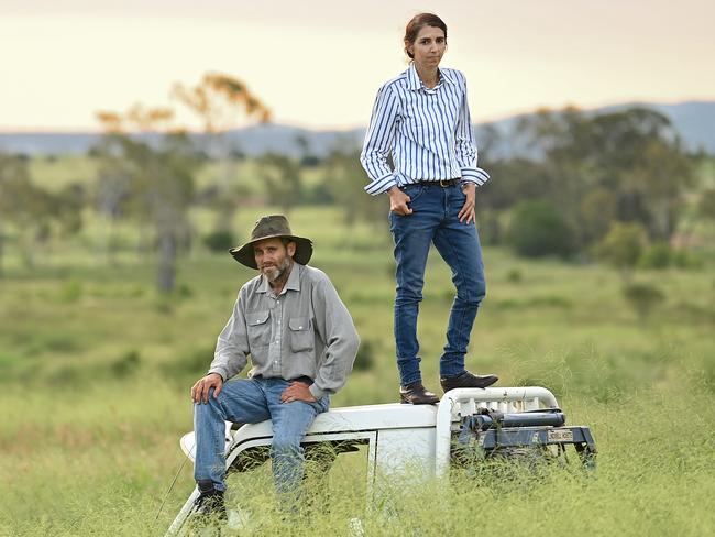 08/12/2021: Grass so tall and lush that it almost fully covers their Land Cruiser, graziers Cedric and Therese Creed stand on top of their old farm ute to look over their property at Smokey Creek, north of Biloela, QLD. Behind them is farming land equally full of potential prime cattle feed, but will instead to be turned into a giant solar farm, to the anger of local farmers like Cedric and Therese who view the development as a waste of prime agricultural land. Lyndon Mechielsen/The Australian