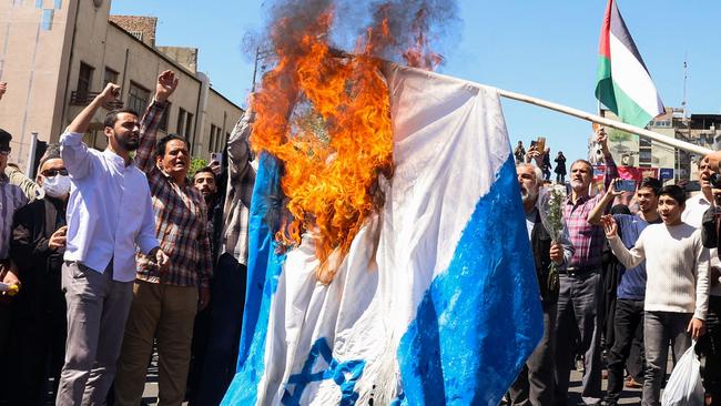 Iranians burn an Israeli flag during the funeral for seven Islamic Revolutionary Guard Corps members killed in a strike in Syria. Picture: AFP.