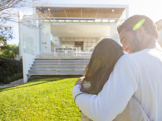 generic; couple in front of house for sale; house sold; real estate; hugging; iSTOCK