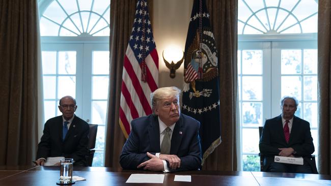 President Donald Trump listens during a meeting with tourism industry executives about the coronavirus in the Cabinet Room of the White House.