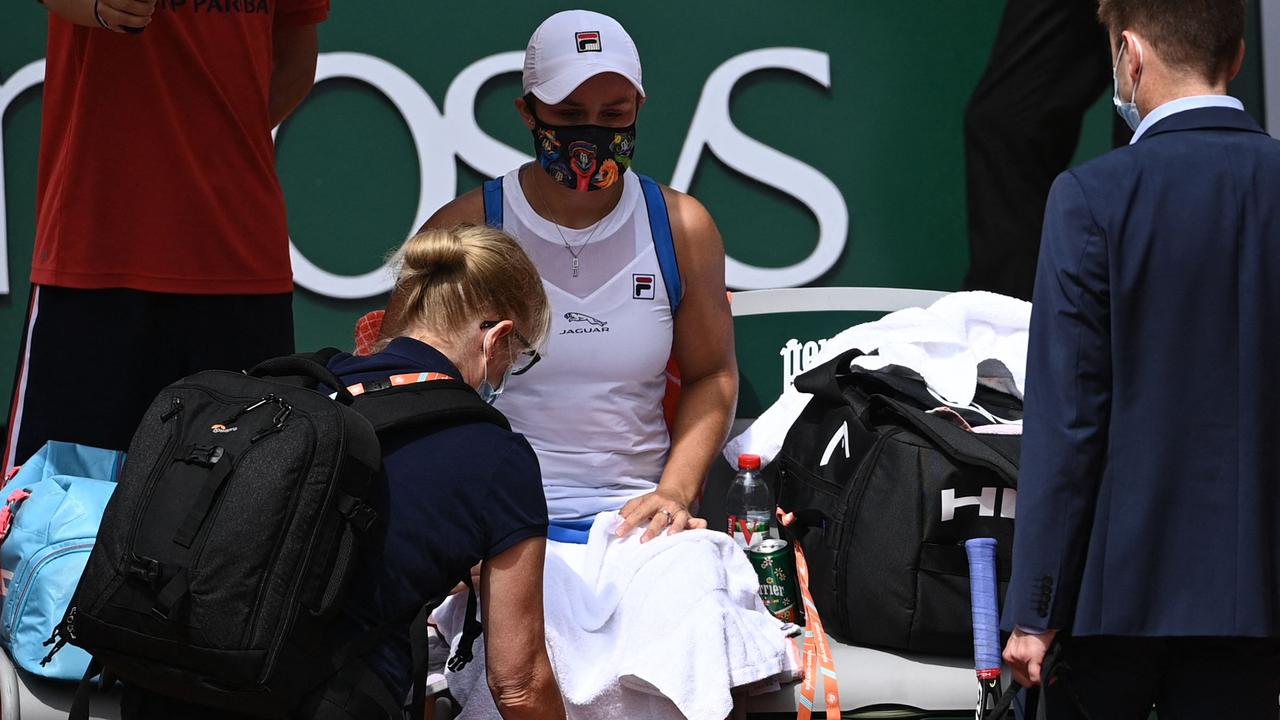 Australia's Ash Barty is treated by medical staff before retiring.