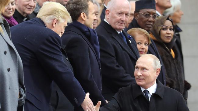 Russian President Vladimir Putin (R) shakes hands with US President Donald Trump overnight at a ceremony at the Arc de Triomphe in Paris commemorating the 100th anniversary of the 1918 armistice, ending World War I.