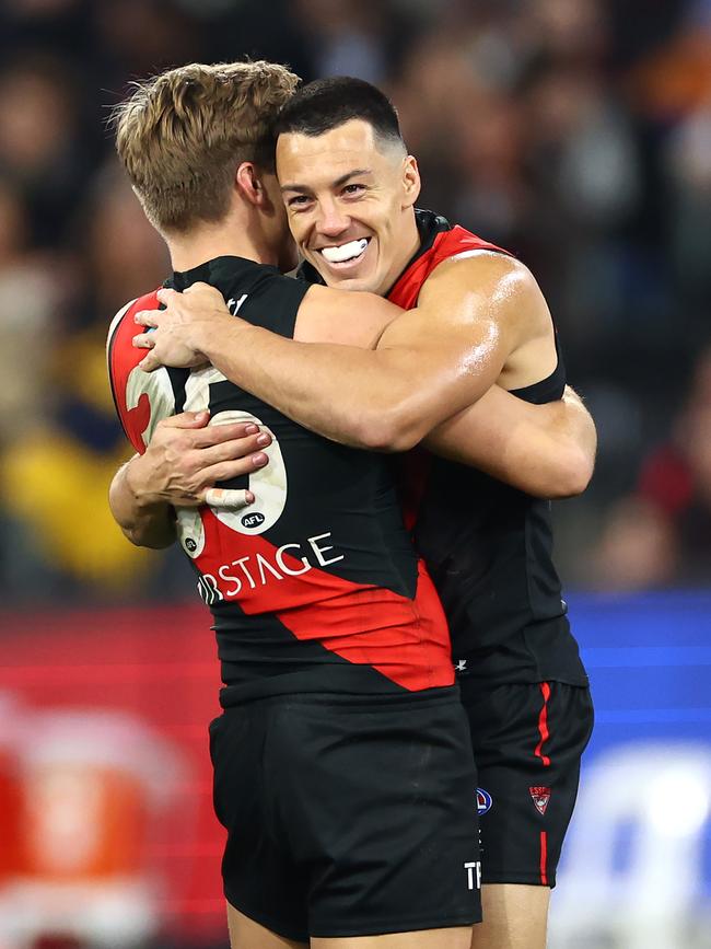 Dylan Shiel, who made an impressive return to the Bombers side, hugs teammate Matt Guelfi. Picture: Quinn Rooney/Getty Images
