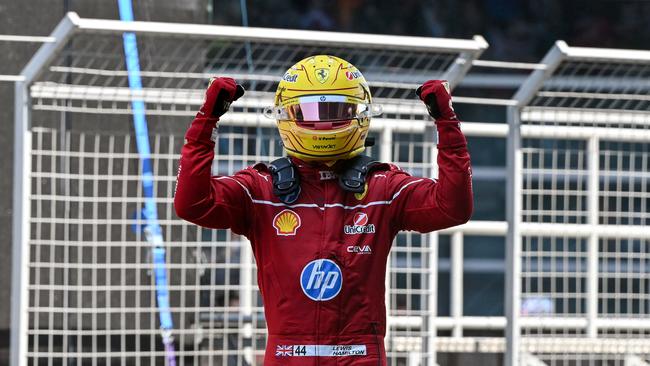 Lewis Hamilton celebrates his first victory as a Ferrari driver. (Photo by GREG BAKER / AFP)