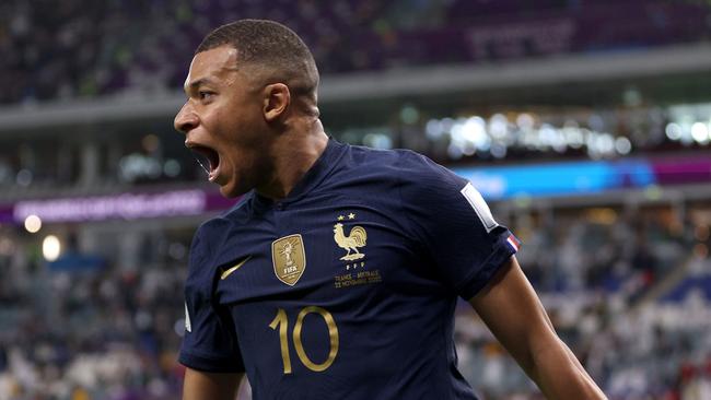 Kylian Mbappe wheels off in celebration after scoring.