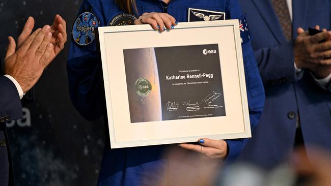 Australian astronaut graduate Katherine Bennell-Pegg holds her certificate for completing the European Space Agency's astronaut basic training. Picture: Ina Fassbender/AFP