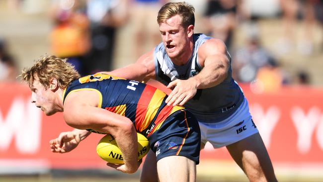 Rory Sloane of the Crows gets caught by Tom Jonas of Power.