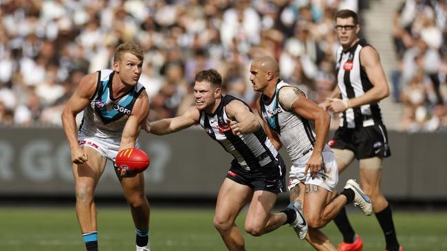 Ollie Wines handballs under pressure from Taylor Adams.