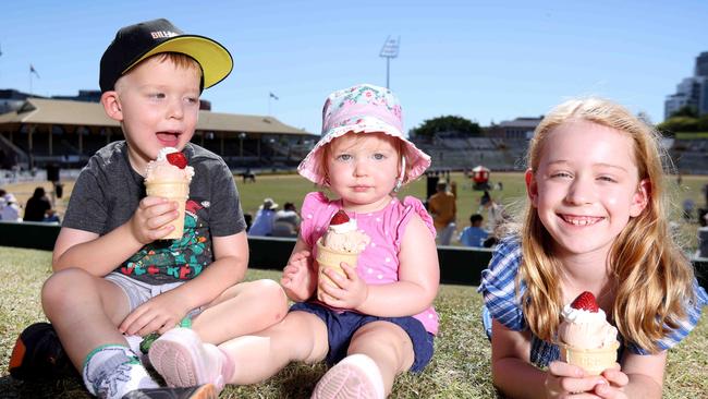 Caleb Schipper 4 yrs, Lara  Schipper 18 months and Kate Schipper 7 yrs from Bellbird Park, eating Strawberry SundaeÃs on the hill. Crowd, Strawberry sundae and dagwood dog contest photos, Ekka Bowen Hills, on Sunday 20th August 2023 - Photo Steve Pohlner