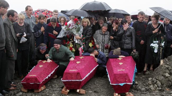 Ossetians weep over the coffins of hostages killed in the school siege during a funeral in Beslan, Russia. Picture: AP