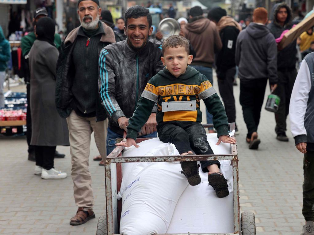 A displaced Palestinian boy pushes a cart loaded with bags of flour they received from the United Nations Relief and Works Agency for Palestine Refugees (UNRWA). Picture: AFP