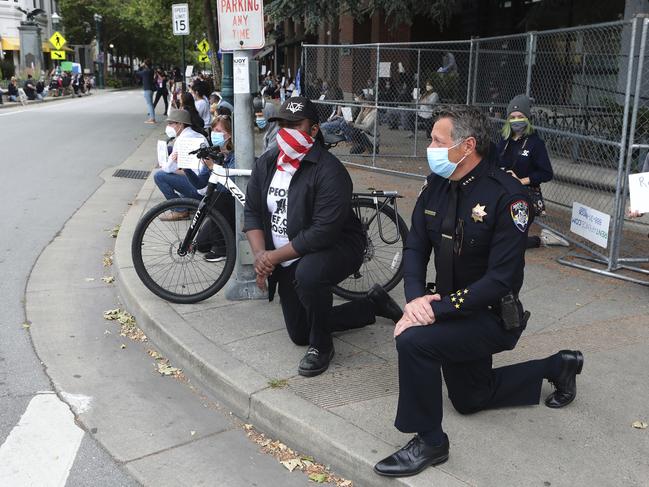 Santa Cruz Mayor Justin Cummings and Police Chief Andy Mills kneel as hundreds gather to honour the memory of George Floyd and bring attention to police violence. Picture: AP