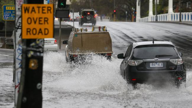 A flooded road is closed at the intersection of Punt Road and Gough Street in Richmond. Picture: Brendan Beckett