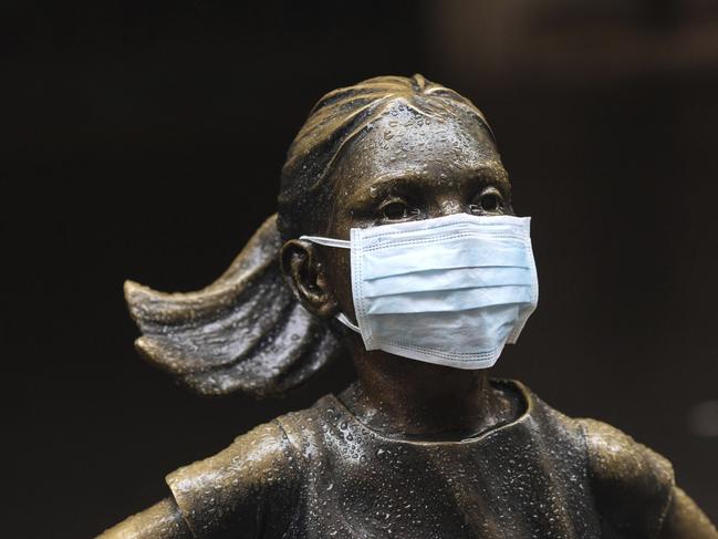 A surgical mask is placed on the famous "Fearless Girl" statue outside the New York Stock Exchange. Picture: AP