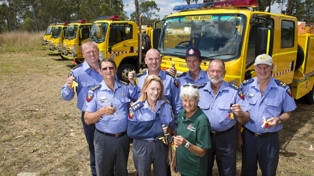 First officers Danny Devers, Errol Noye, Jason Polzin, Judy Ferrari, Colleen Yarrow, David Kretschmer, Jeremey Banks and Ron Barker from around the region hold up their keys to eight new Yellow Rural Fire Trucks.