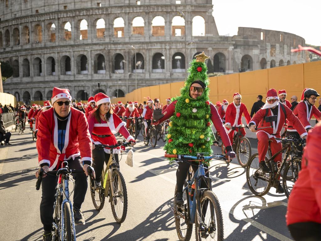 People take part in a Santa ride near Rome’s Colosseum to raise funds for children with cancer. Picture: Antonio Masiello/Getty Images