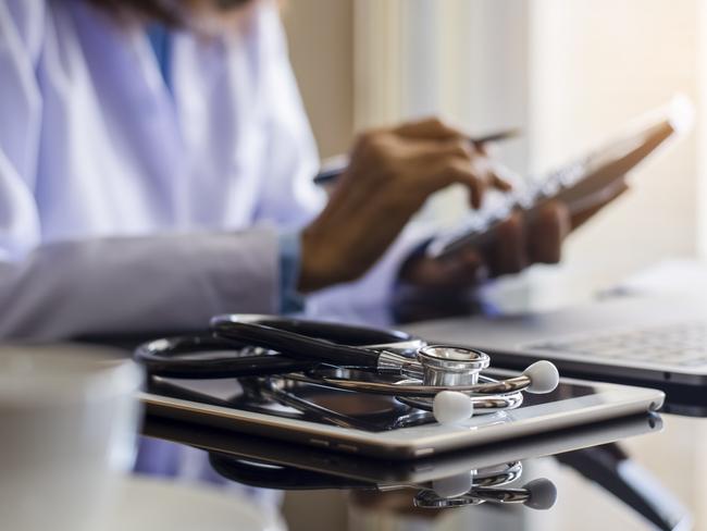 Doctor or physician using calculator and work on laptop computer with medical stethoscope and digital tablet on the desk at clinic or hospital. Medical healthcare costs ,fees and revenue concept.