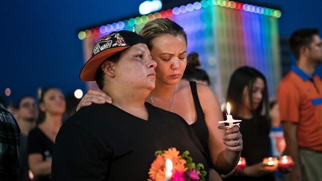 Nicole Edwards and her wife Kellie Edwards observe a moment of silence during a vigil outside the Dr. Phillips Center for the Performing Arts for the mass shooting victims at the Pulse nightclub in Orlando, Florida. Picture: AFP