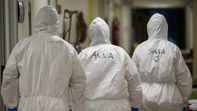 Medical staffers, their first names written on their protective outfits, walk in the respiratory ward of the San Filippo Neri hospital, in Rome. Picture: Cecilia Fabiano/LaPresse via AP