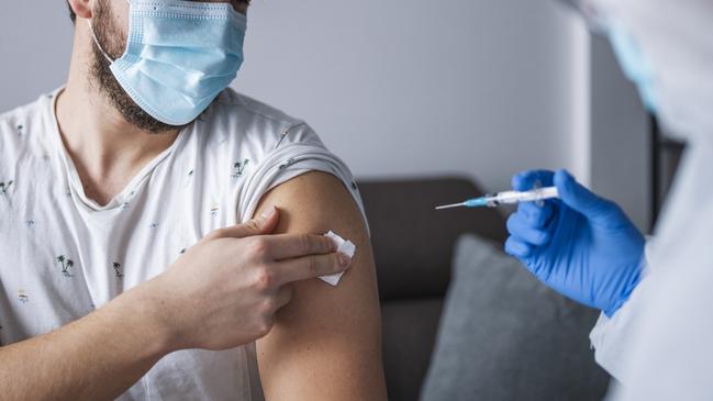 A healthcare frontline worker injecting COVID-19 vaccine to patient.