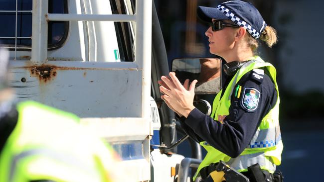 A police officer speaks to motorists at the border. Picture: Adam Head