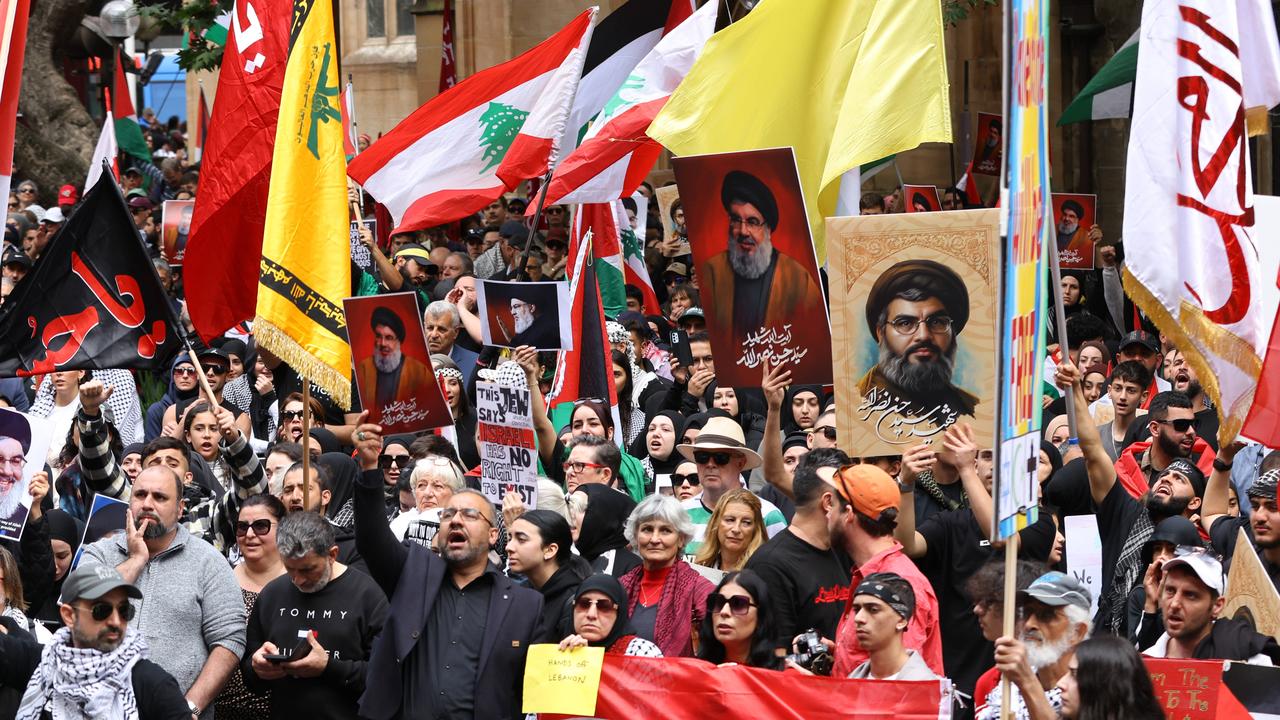 Protesters hold up pictures of Hezbollah leader Hassan Nasrallah and the Hezbollah flag at Town Hall in Sydney. Picture: NewsWire / Damian Shaw