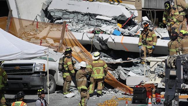 MIAMI, FL - MARCH 15: Miami-Dade Fire Rescue Department personel and other rescue units work at the scene where a pedestrian bridge collapsed a few days after it was built over southwest 8th street allowing people to bypass the busy street to reach Florida International University on March 15, 2018 in Miami, Florida. Reports indicate that there are an unknown number of fatalities as a result of the collapse, which crushed at least five cars.   Joe Raedle/Getty Images/AFP == FOR NEWSPAPERS, INTERNET, TELCOS & TELEVISION USE ONLY ==